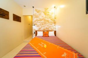 a small room with a bed with an orange laptop on it at Casa Seraya Dalung in Dalung