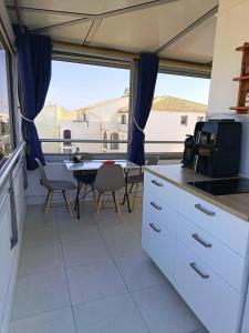 a kitchen with a table and a microwave at studio cabine vue sur mer in Sète