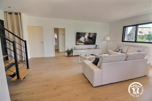 a living room with a white couch and a table at Enez bihan in Plougrescant