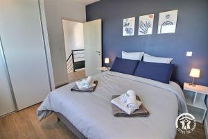 a bedroom with a large bed with towels on it at Enez bihan in Plougrescant