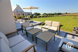 a patio with couches and chairs and a table at Enez bihan in Plougrescant