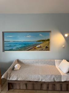 a painting hanging on a wall above a bed at Filoxenia Studios in Skliri