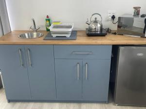 a kitchen counter with blue cabinets and a sink at Net Dankbaar in De Kelders