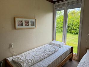 a room with two beds in front of a window at Keizerskroon 239 in Julianadorp