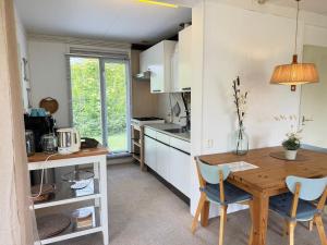 a small kitchen with a wooden table and chairs at Keizerskroon 239 in Julianadorp +10 photos