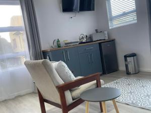 a living room with a chair and a table at Net Dankbaar in De Kelders
