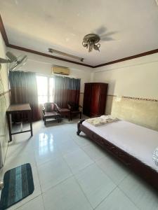 a bedroom with a bed and a couch and a chair at Khách Sạn Vũ Nam Hưng in Ấp Hưng Lộc