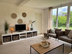 a living room with a tv and a couch and a table at Keizerskroon 239 in Julianadorp