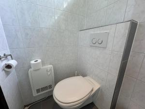 a bathroom with a toilet and a toilet paper dispenser at Keizerskroon 239 in Julianadorp