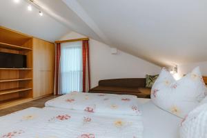 a small bedroom with two beds and a couch at Appartement Lackner mit Seeblick in Weissensee