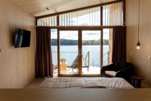 a bedroom with a large window with a view of the water at Bella Lake Resort in Kuopio