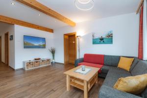 a living room with a couch and a table at Appartement Lackner mit Seeblick in Weissensee
