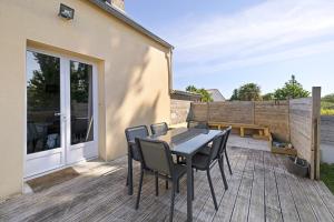 a patio with a table and chairs on a deck at Gite cap 3KM plages in Telgruc-sur-Mer