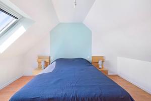 a bedroom with a blue bed in a attic at Gite cap 3KM plages in Telgruc-sur-Mer