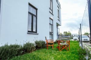 two chairs and a table in the grass next to a building at Apartment in Tilisi in Gatimu