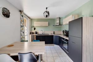 a kitchen with a wooden table and a refrigerator at Gite Aber 3km plages in Telgruc-sur-Mer