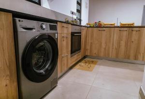 a washing machine in a kitchen with wooden cabinets at Apartment in Tilisi in Gatimu