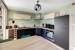 a kitchen with blue cabinets and a kitchen table at Gite Aber 3km plages in Telgruc-sur-Mer +11 photos