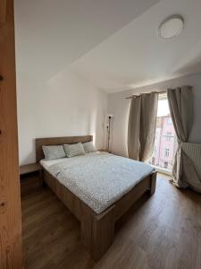 a bedroom with a bed and a large window at StayCentralcz- Loft in Opava +4 photos