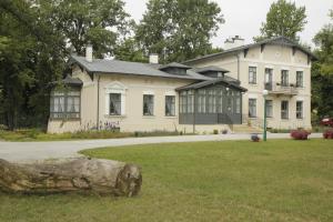 a large house with a large tree stump in front of it at Lawendowy Dworek in Lublin