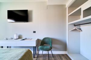 a bedroom with a desk and a green chair at Hostal Sol y Miel in Benalmádena