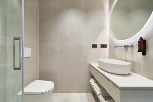 a bathroom with a toilet and a sink and a mirror at Hostal Sol y Miel in Benalmádena +44 photos