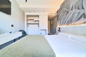 a bedroom with a large bed and a tv at Hostal Sol y Miel in Benalmádena