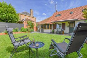 a yard with two chairs and a table and a house at Le 10 de coeur in Lusigny-sur-Barse
