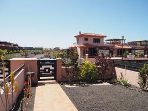 a house with a gate on the side of it at Fuerte Wave House in Lajares +15 photos