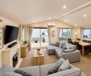 a living room with two couches and a television at Seaview Holiday Rentals - Pebble Beach in Whitstable