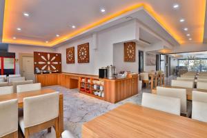 a restaurant with wooden tables and white chairs at Side Ertaş Otel in Side
