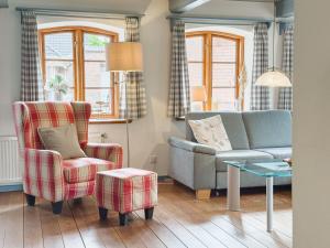 a living room with a couch and a chair at Reetdachhaus Silvi in Schwabstedt