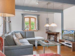 a living room with a couch and a table at Reetdachhaus Silvi in Schwabstedt