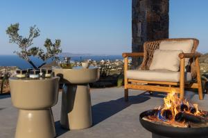 a fire pit and a chair on a patio at Elysium Caved Villas - Carved From Calm by etouri in Heraklio