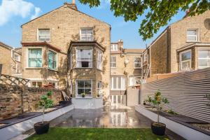 an exterior view of a brick building with potted plants at The Cozy Stays Hackney House in London