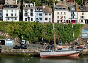 a boat docked in the water next to a city at Harbour View in Brixham
