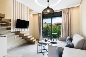 a living room with a couch and a tv at Mulberry Suites in Paralia Dionysiou