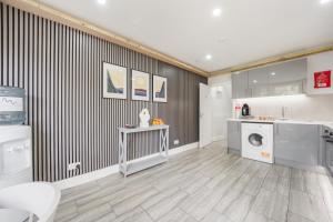 a laundry room with a washer and dryer at The Cozy Stays Hackney House in London