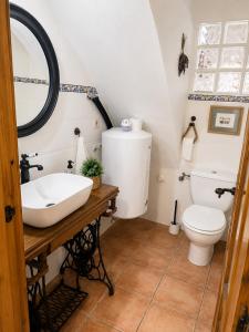 a bathroom with a white toilet and a sink at La Casonita in Alpuente +16 photos