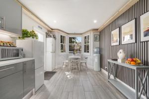 a kitchen with white appliances and a dining room at The Cozy Stays Hackney House in London