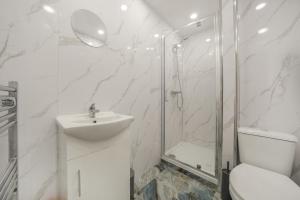 a bathroom with a shower and a toilet and a sink at The Cozy Stays Hackney House in London +47 photos