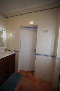 a bathroom with a white door and a sink at Casa de campo em Riachos in Riachos +3 photos