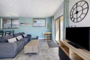 a living room with a couch and a large clock on the wall at Gite Dune 3km plage in Telgruc-sur-Mer