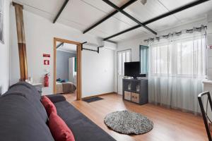 a living room with a couch and a tv at Casinha do coração do Oeste in Cadaval