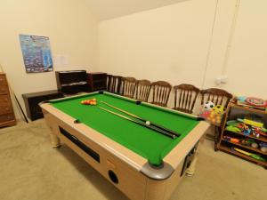 a living room with a pool table and chairs at Foyle Cottage in Strabane