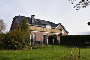 a large house with a yard with a playground at Ferienappartment Lhasa Apso in Dornum