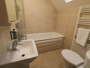 a bathroom with a sink and a tub and a toilet at Foyle Cottage in Strabane +25 photos