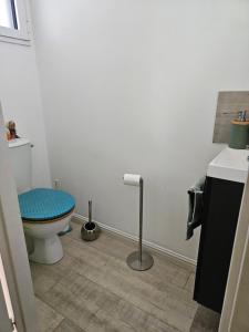 a bathroom with a toilet with a blue seat at Chambre privée proche GR & Véloroute in Plougonvelin