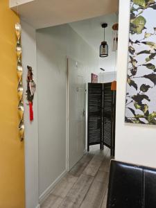 a room with a hallway with a black chair and a painting at Chambre privée proche GR & Véloroute in Plougonvelin