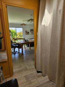 a view of a living room with a table and a curtain at Chambre privée proche GR & Véloroute in Plougonvelin +1 photo